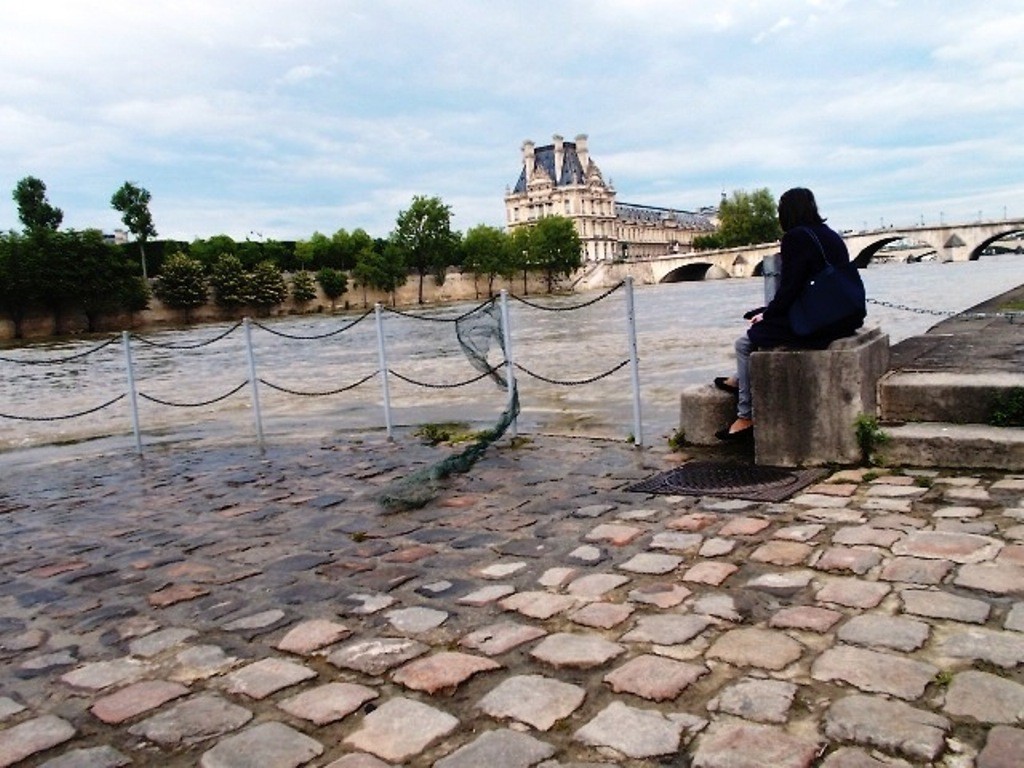 La seine arrive sur les quais au loin un batiment du louvre 1